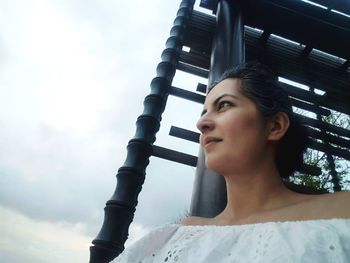 Low angle view of thoughtful woman against sky