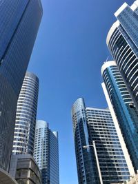 Low angle view of modern buildings against clear blue sky