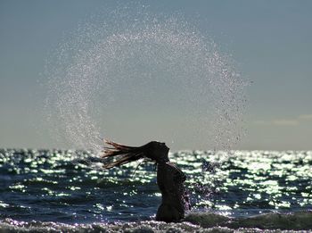 Water splashing in sea against sky