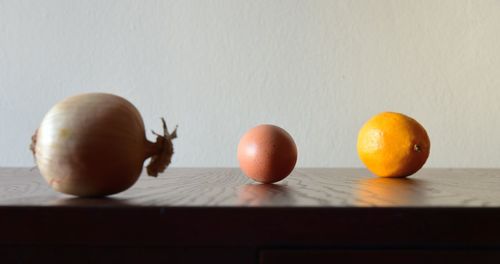 Close-up of fruits on table against wall