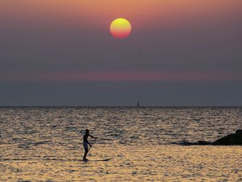 View of man on paddle board in sea