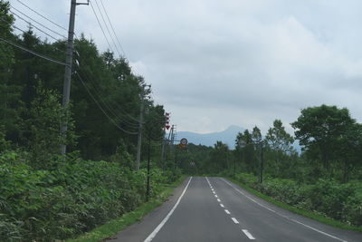 Road amidst trees against sky