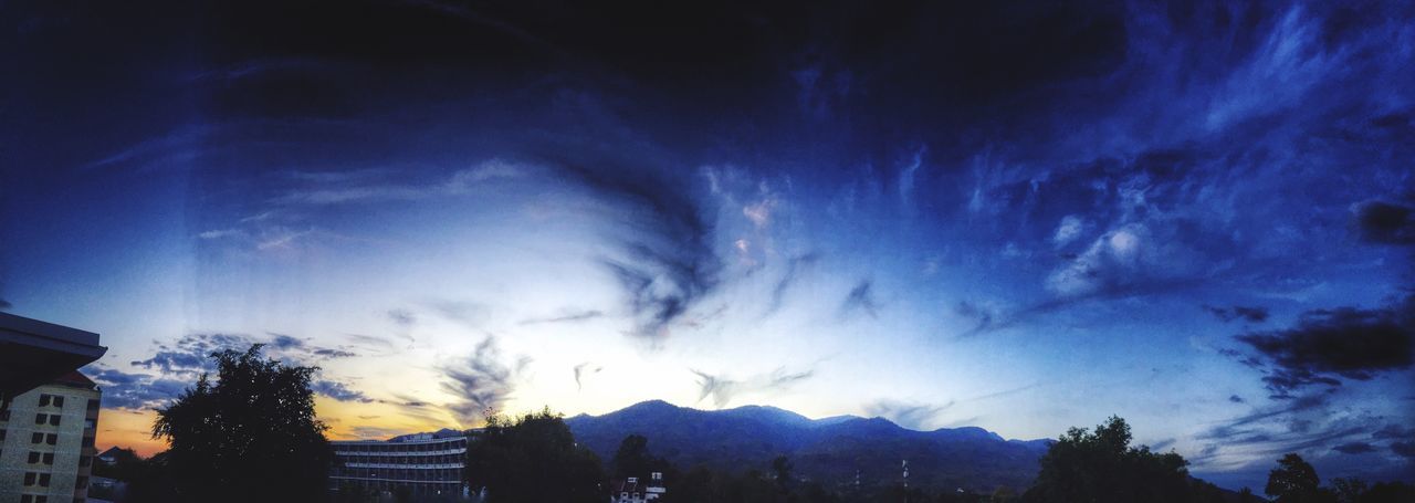 sky, building exterior, cloud - sky, built structure, tree, architecture, silhouette, low angle view, beauty in nature, scenics, blue, cloud, house, cloudy, nature, mountain, dusk, tranquility, outdoors, residential structure