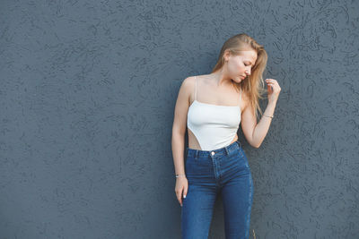 Full length of woman standing against wall