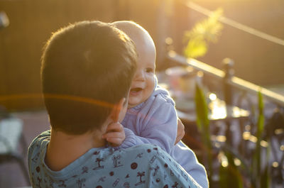 Rear view of two brothers laughing in evening