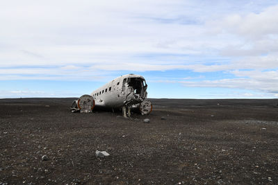 Abandoned airplane on field against sky