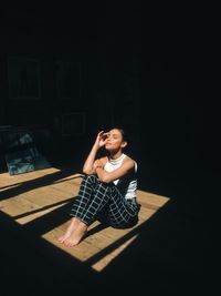 Portrait of a beautiful young woman sitting on floor