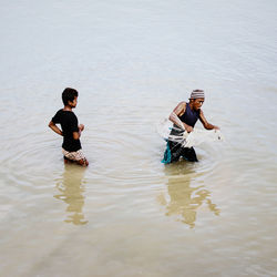 High angle view of fisherman holding fishing net while standing in lake