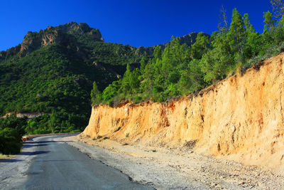 Empty road against clear blue sky