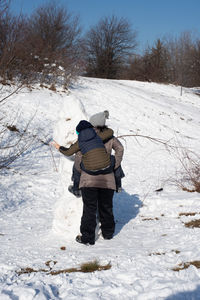 Rear view of woman on snow covered field