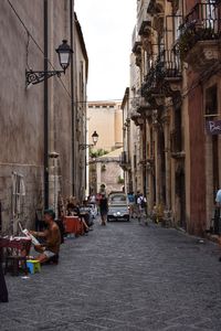 People on street amidst buildings in city