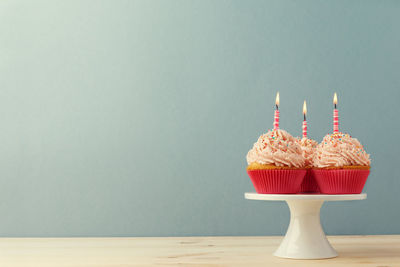 Cropped hand of woman with arms raised against wall