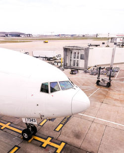 Airplane on airport runway against sky