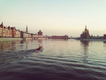 River and buildings against clear sky in city