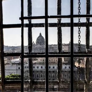 Buildings against sky seen through glass window