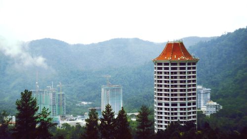 Panoramic view of cityscape and mountains against sky