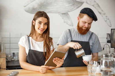 Portrait of smiling young woman working in laptop