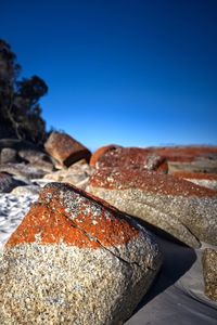 Close-up of rusty metal against clear blue sky