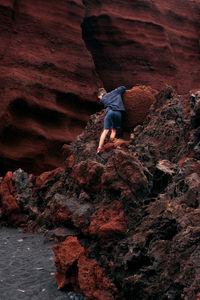 Rear view of man walking on rock