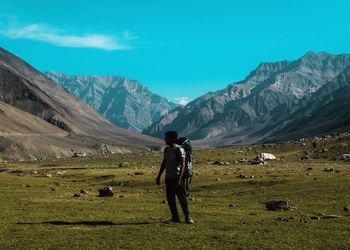 Rear view of man on field against mountains