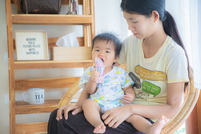 Woman holding baby sitting with hands