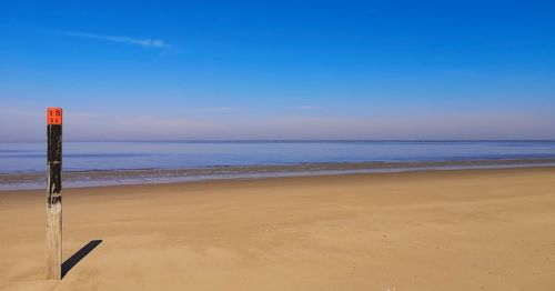 Scenic view of beach against blue sky