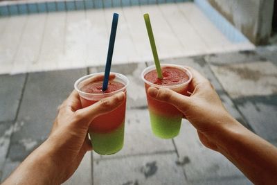 Two hands holding slush ice drinks during summer time 