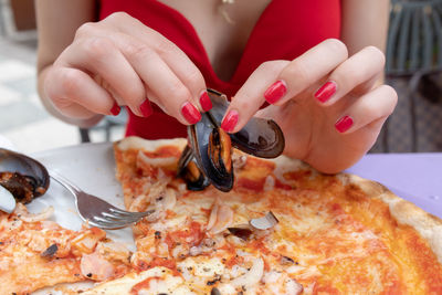 Close-up of hand holding pizza