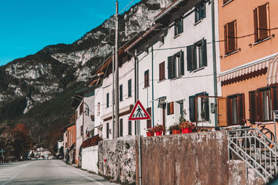 Road by buildings against sky in city