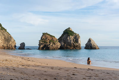 Caucasian woman on an empty wild beach in arrabida natural park, in portugal