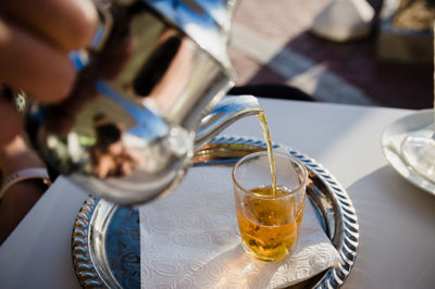 Midsection of woman holding drink on table