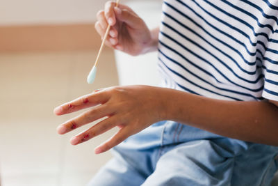 Asian child girl cleaning her wound on her finger injury and perform first aid by herself 