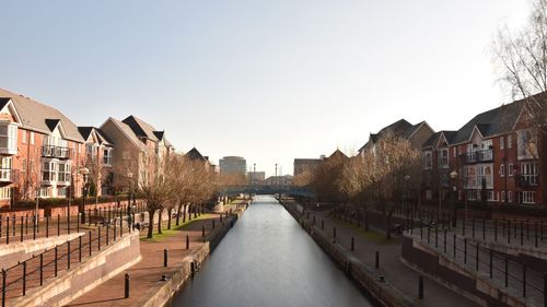 Canal amidst buildings against sky in city