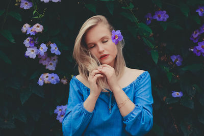 Young woman with eyes closed by plants