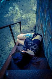 High angle view of woman sitting on wall