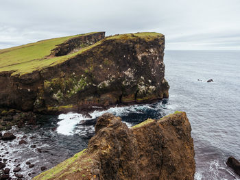 Rock formations by sea against sky