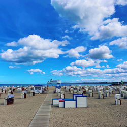 Group of people on beach against blue sky