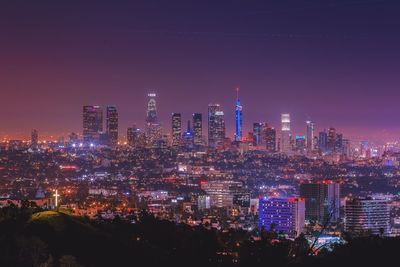 Illuminated cityscape against sky at night