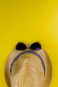 Close-up of sunglasses against yellow background