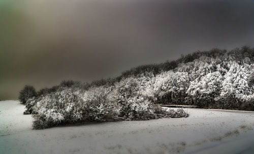 Scenic view of snow covered land against sky