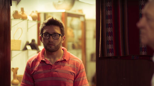 Portrait of young man standing at home