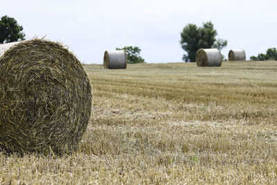 Hay bales on field against sky