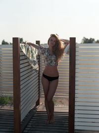 Portrait of woman standing by built structure