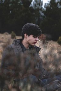 Young man looking away in forest