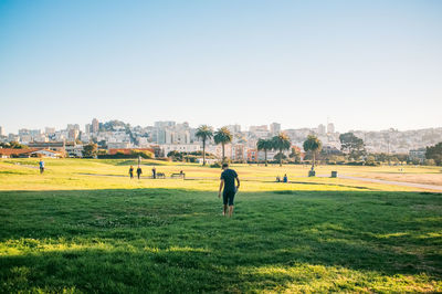 View of grassy field against clear sky