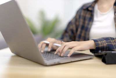 Midsection of man using laptop on table