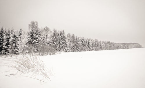 Snow covered landscape against clear sky