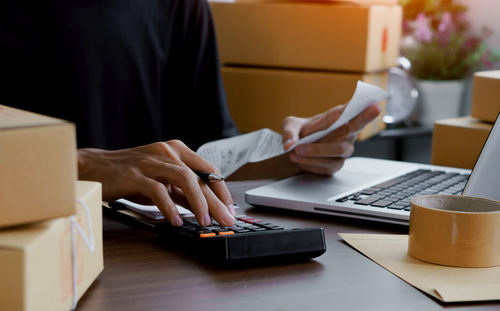 Midsection of man using laptop on table