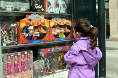 Rear view of girl standing at store
