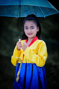 Portrait of young woman holding umbrella